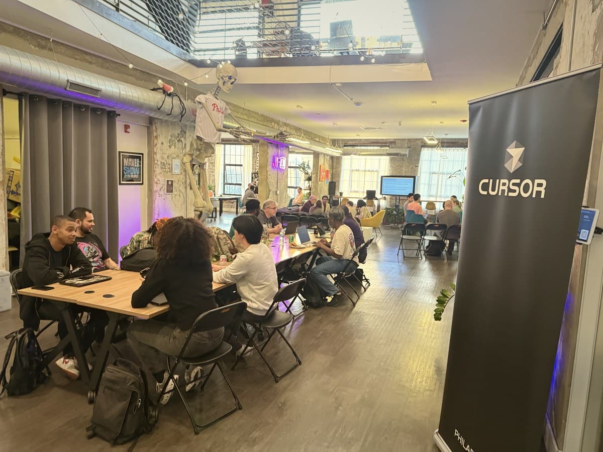 Cursor Meetup Philadelphia attendees co-working next to the Cursor banner