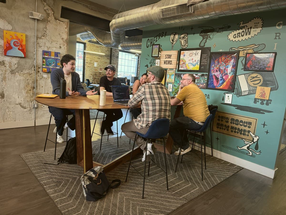 Attendees in a breakout discussion beside the Indy Hall mural